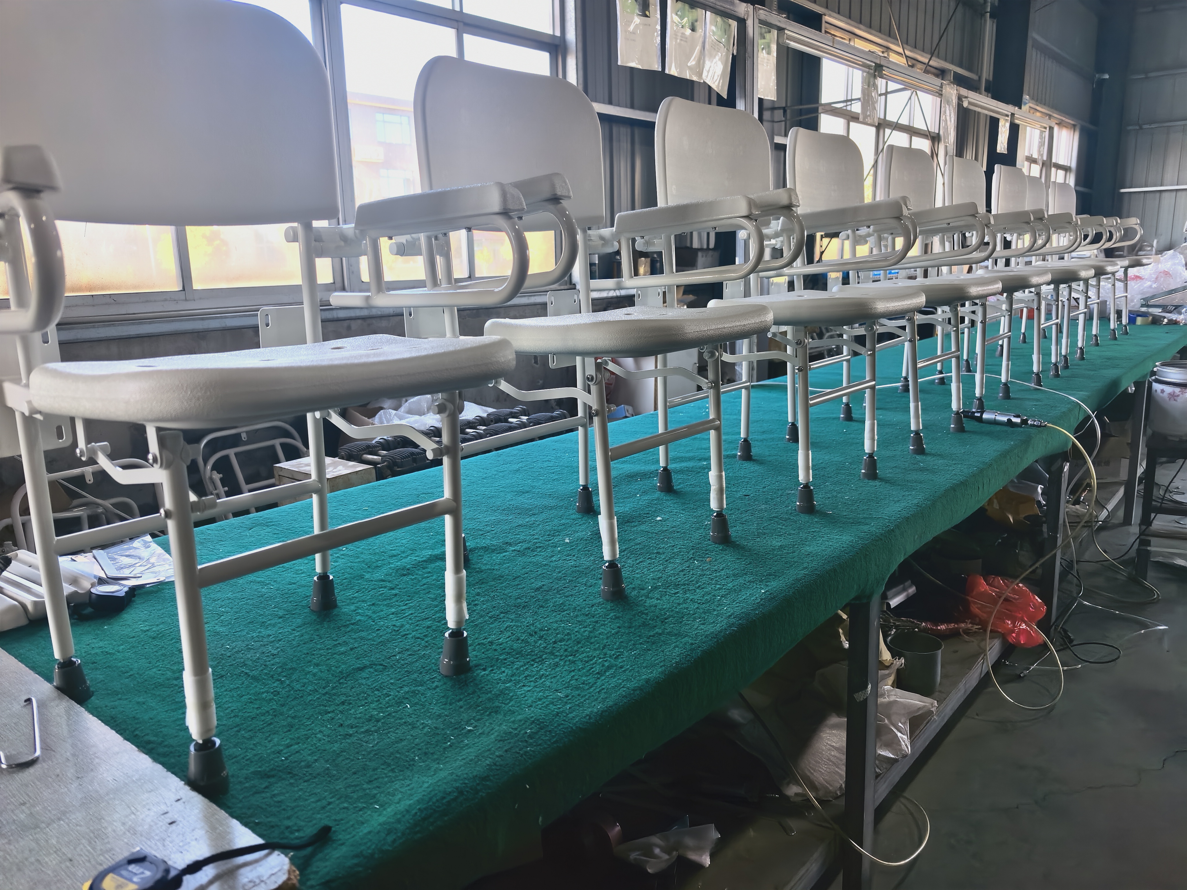 Rows of assembled shower chairs on the Donghe production floor